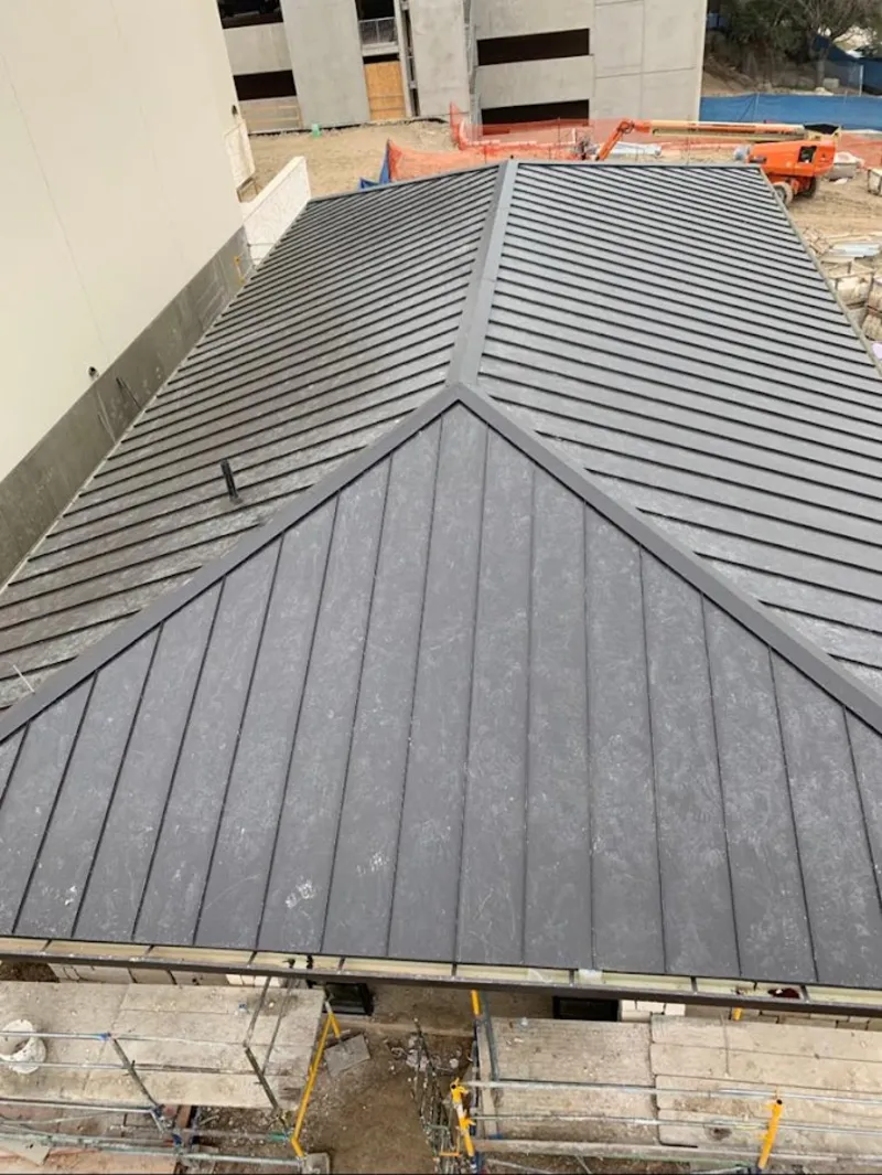 Commercial metal roof construction with crane equipment in Casper