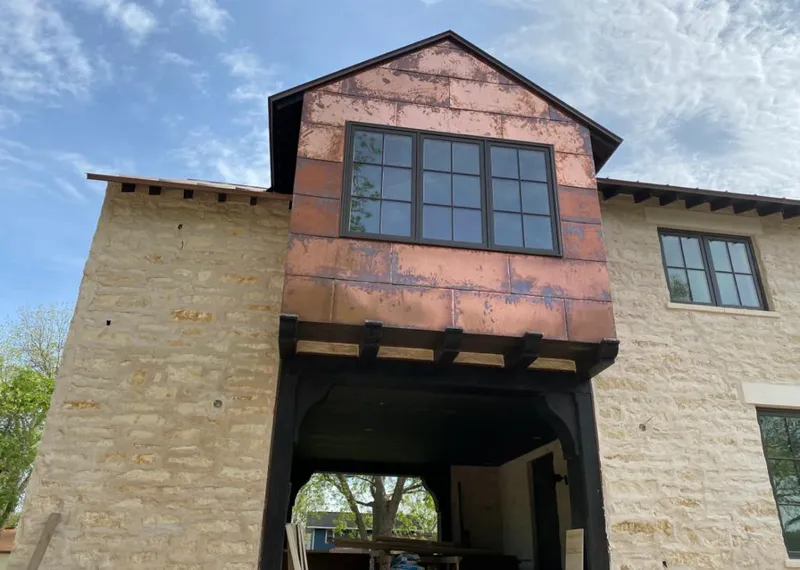 Copper metal panel facade on a stone building for Roof Repair in Casper